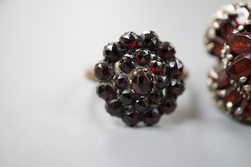 A Victorian garnet cluster set gilt metal dress ring, one other garnet set cluster ring and a garnet paste set hinged bangle.